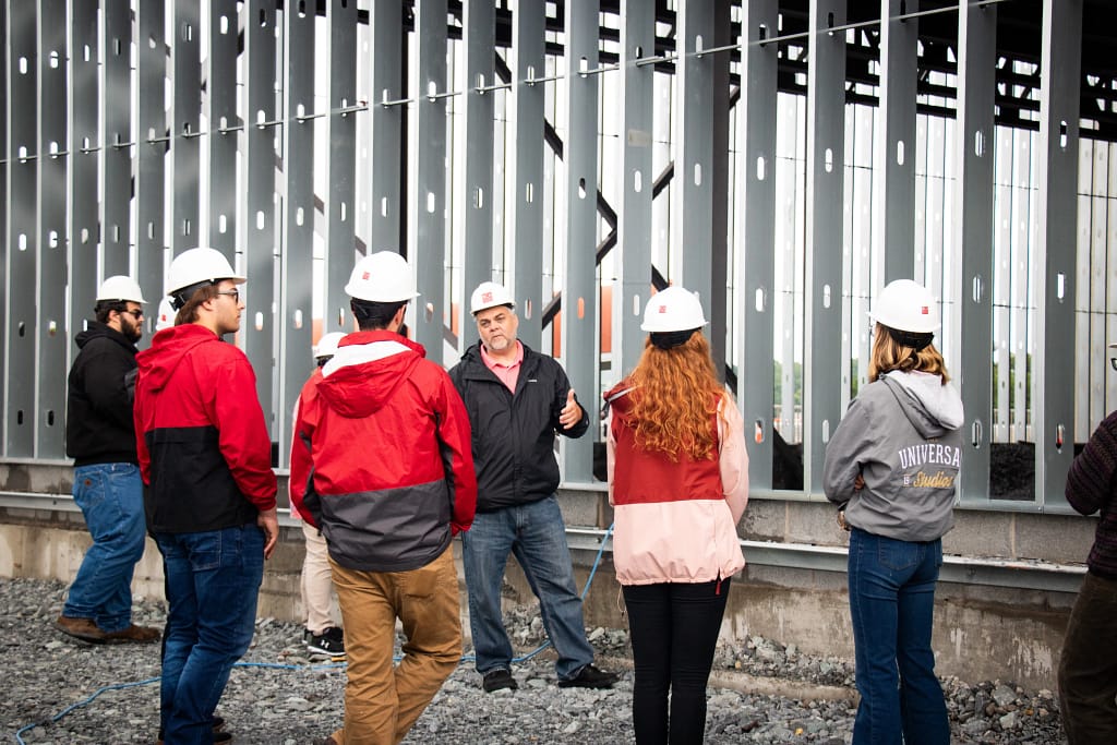 CEO Travis Overton speaks to interns in hard hats at local project site for new YMCA.